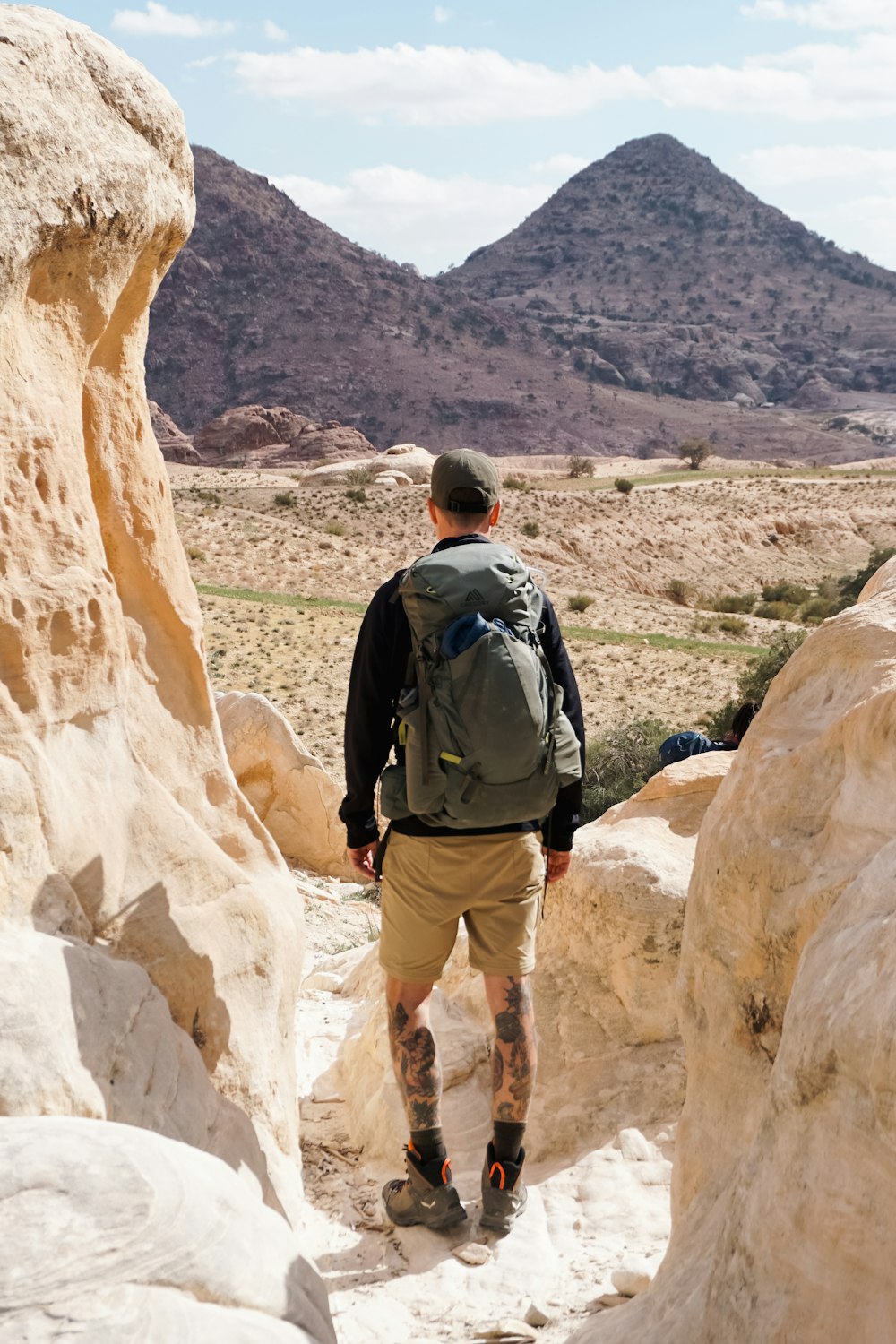 a man with a backpack is walking through some rocks