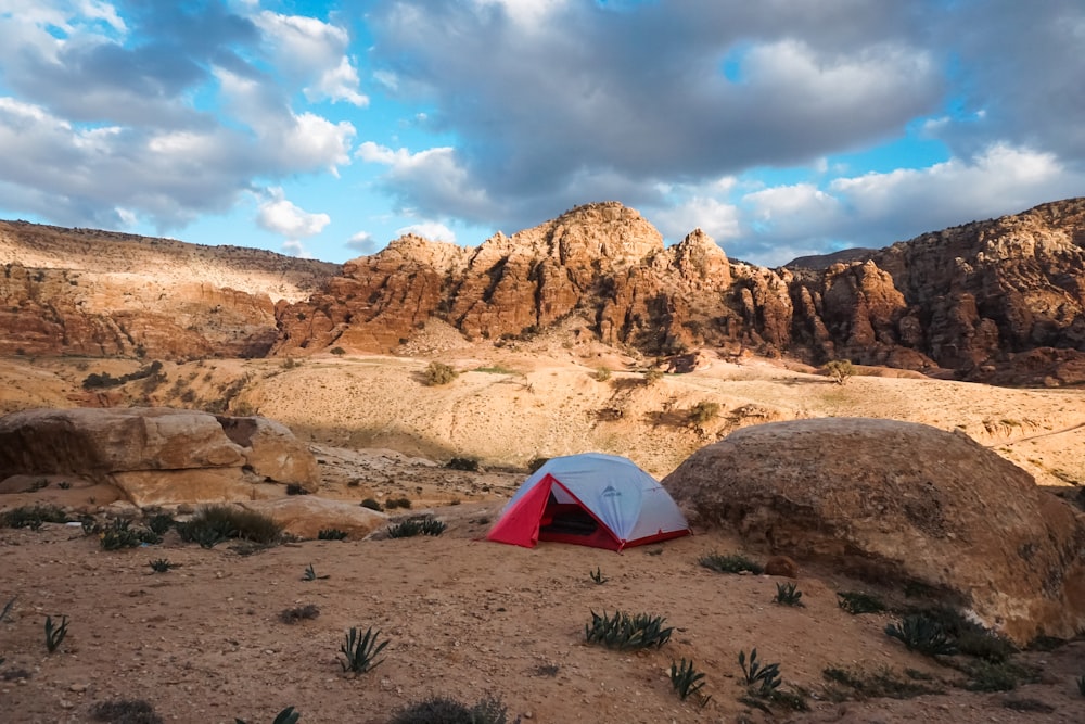 a red and white tent sitting on top of a desert