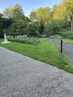 A serene backyard featuring a manicured lawn, trimmed shrubs, and a winding stone pathway.
