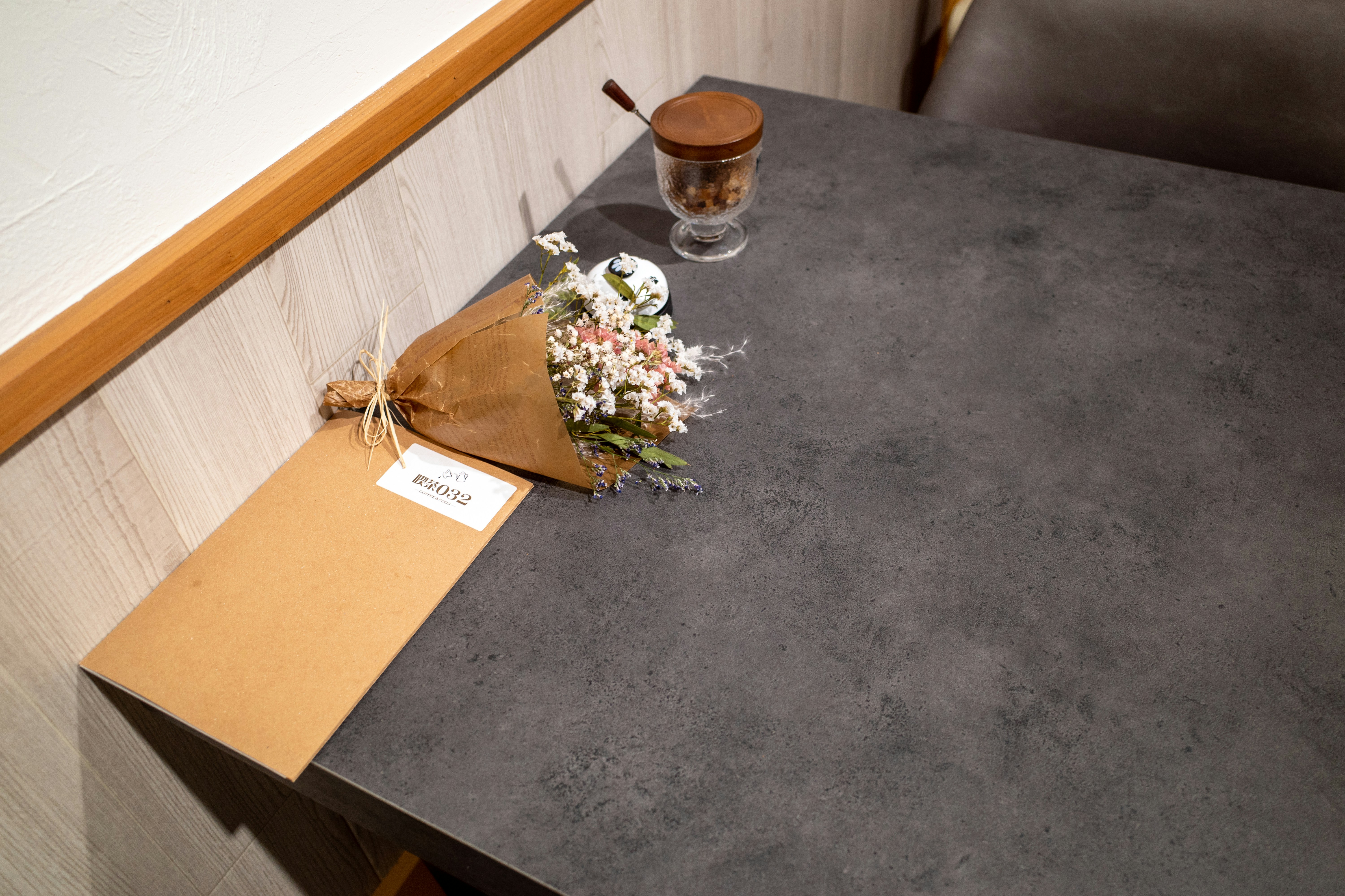 a bouquet of flowers on a table next to a glass of water