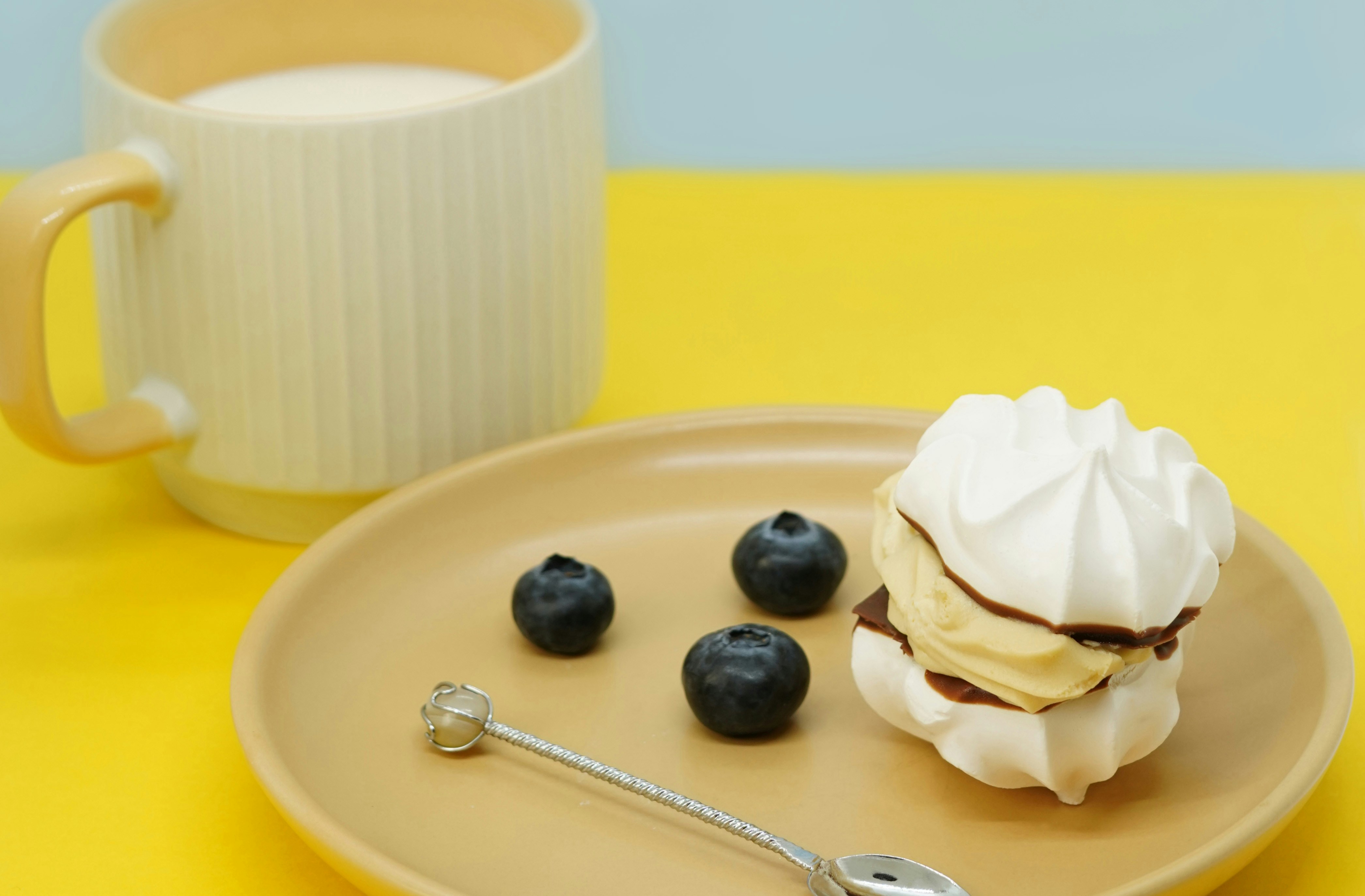 a plate of ice cream with blueberries and a cup of coffee