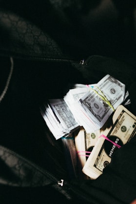 a bag filled with lots of money sitting on top of a table