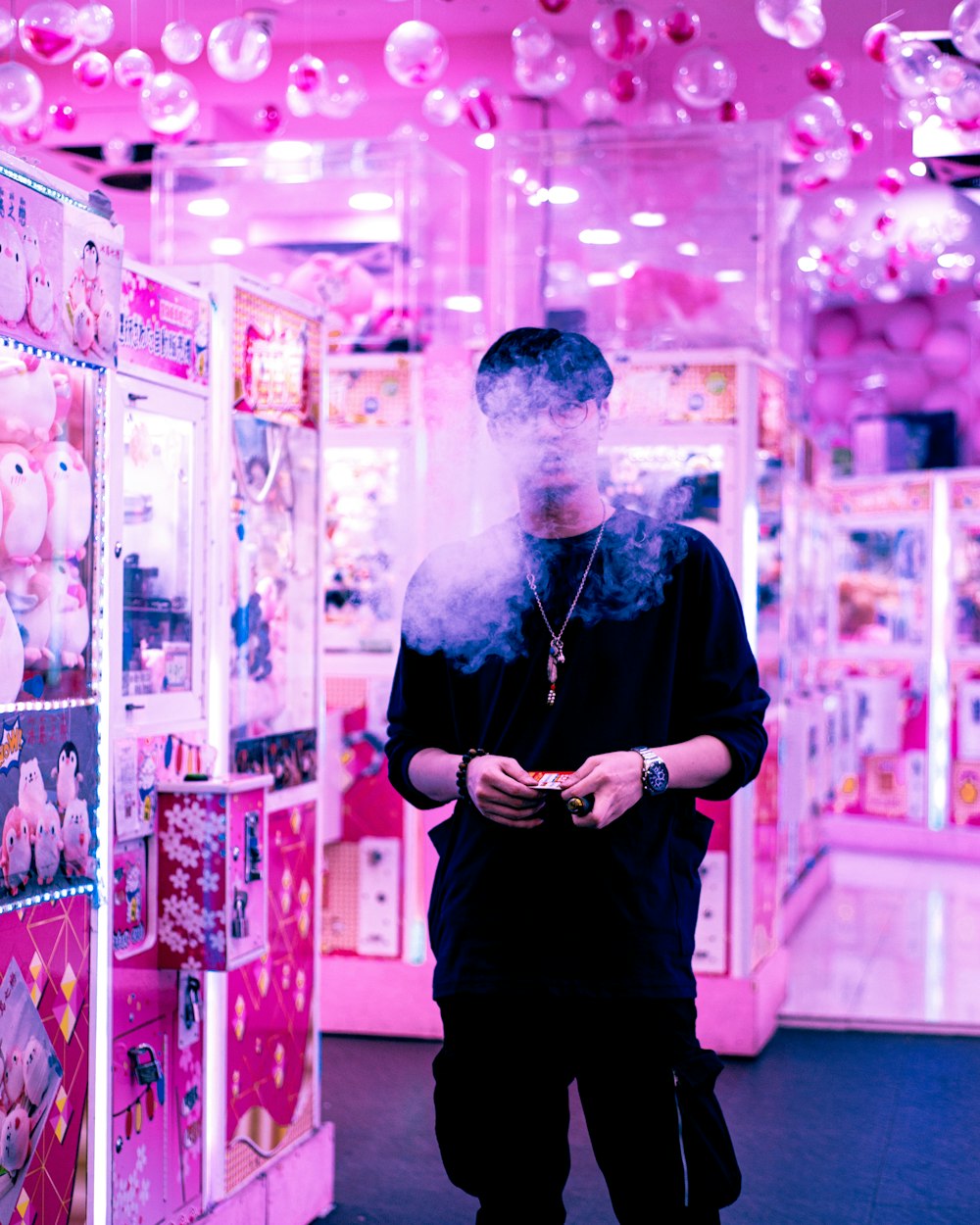 a man standing in front of a pink candy machine