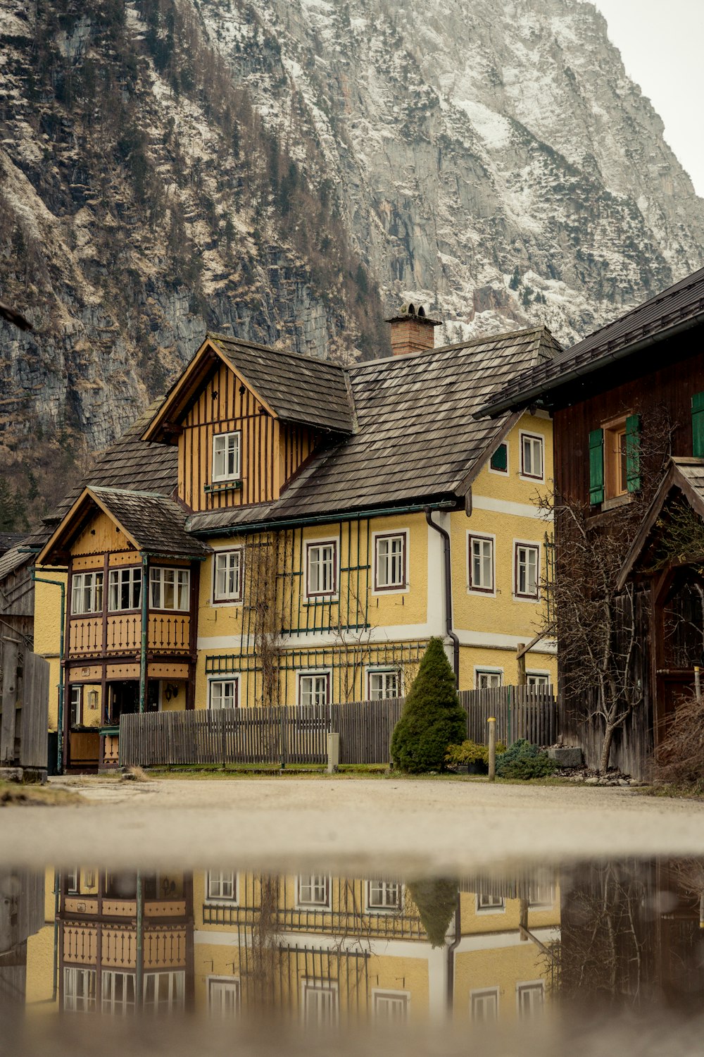 a yellow house with a mountain in the background