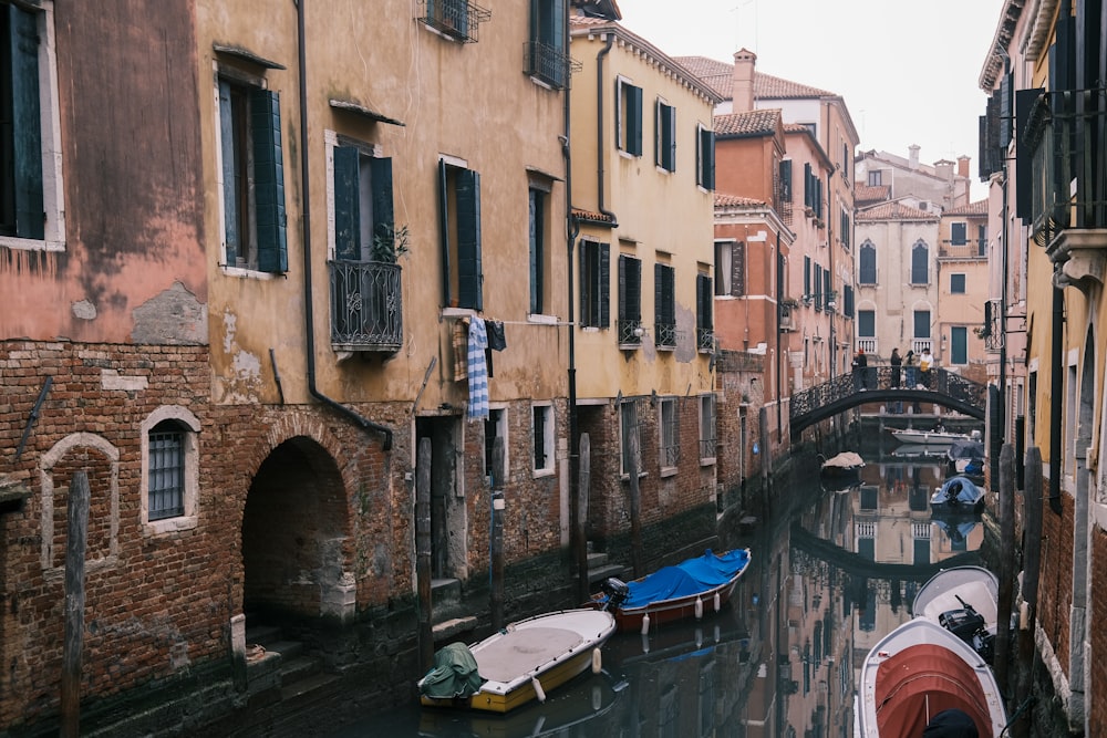 a canal with several boats in it next to buildings