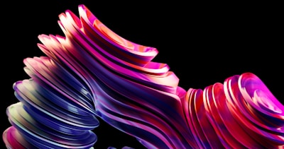 A series of smooth, abstract, layered shapes with vibrant colors including pink, purple, and blue flowing against a black background. The shapes appear to undulate and curve in an organic manner, suggesting movement.