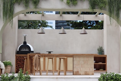 a patio with a table and chairs and a grill