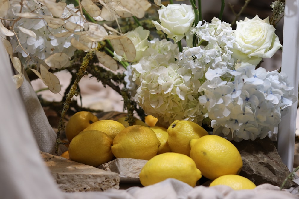 a bunch of lemons and white flowers on a table