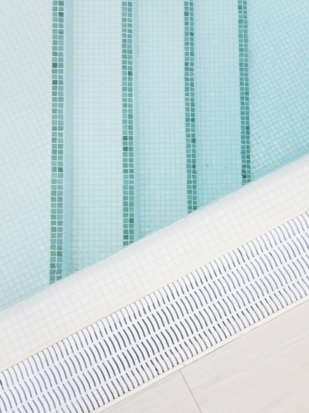 a man sitting on a bench next to a swimming pool