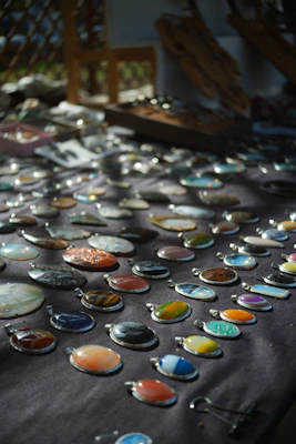Colorful gemstone pendants hanging from fine leather cords against a blurred garden backdrop.