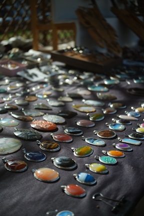 An array of colorful natural stone necklaces displayed on a linen cloth, showcasing their unique textures.
