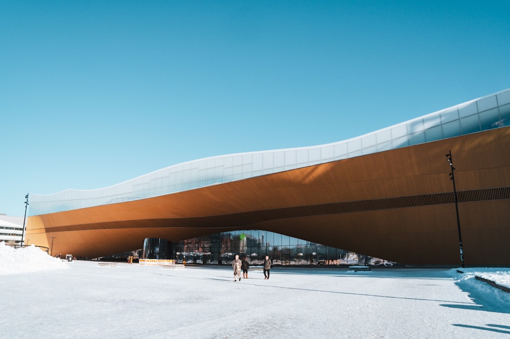 two people walking in front of a large building