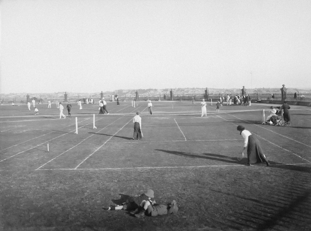 a black and white photo of people playing tennis