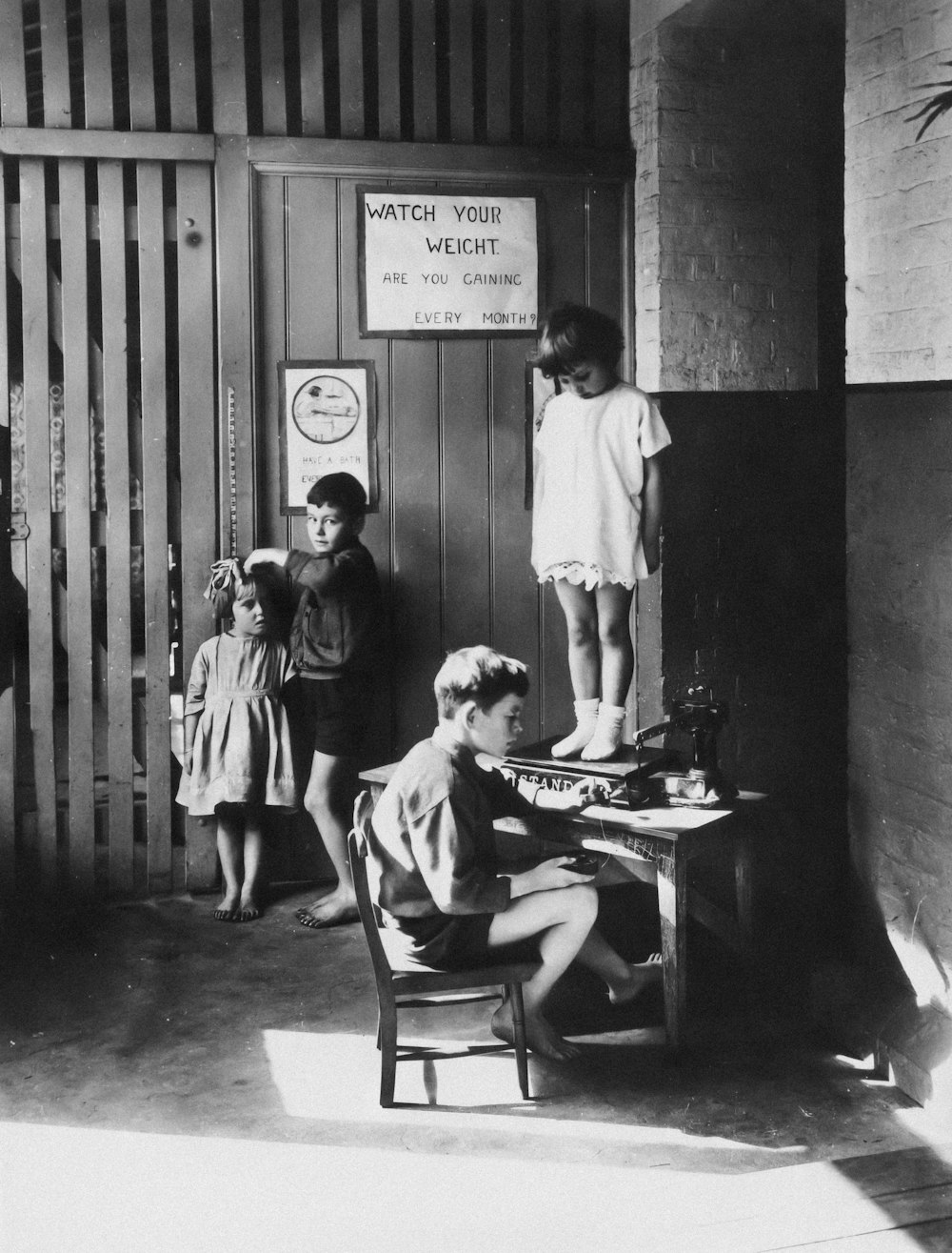 a black and white photo of a boy sitting in a chair in front of a