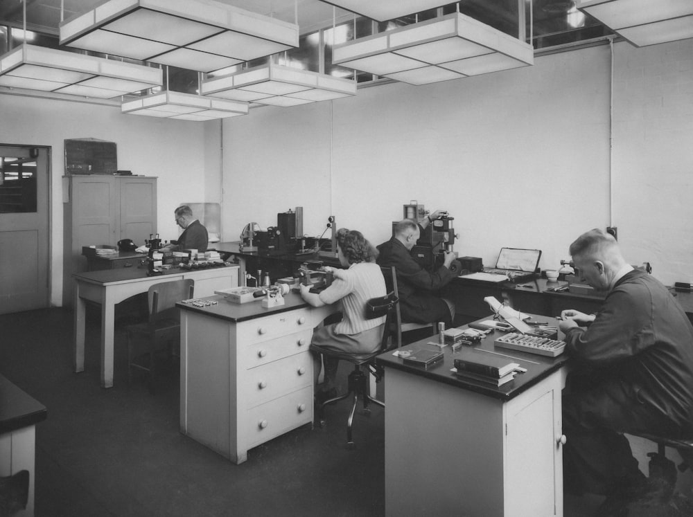 a black and white photo of people working in an office