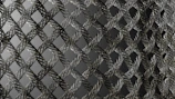 Close-up of stainless steel woven mesh with a navy blue background.