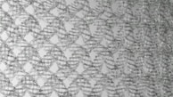Interwoven metallic wireframes create a lattice-like pattern. The cables form a complex, repeating geometric structure, giving the impression of a mesh or net. The overall design is symmetrical and organized, producing a three-dimensional visual effect.