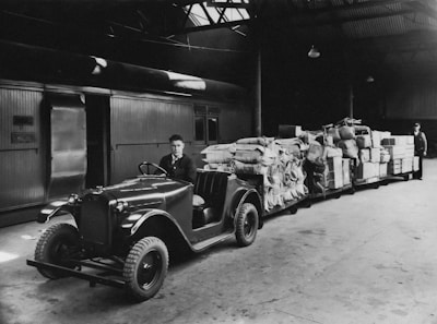a black and white photo of a man sitting on a truck