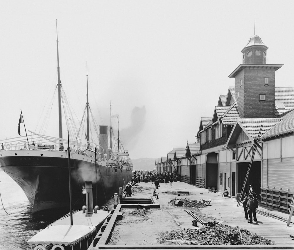 a black and white photo of a boat docked at a dock