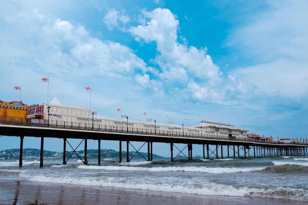 a pier on a beach with waves crashing in front of it