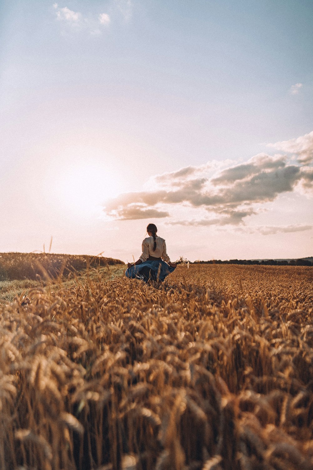 a person sitting in a field of wheat
