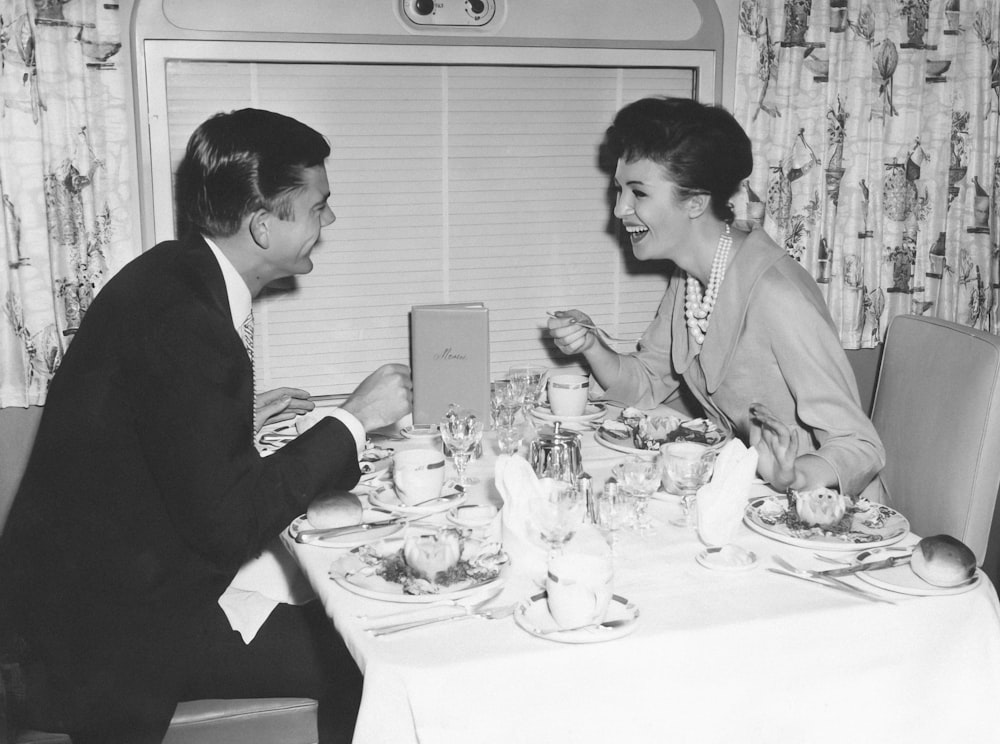 a man and woman sitting at a dinner table