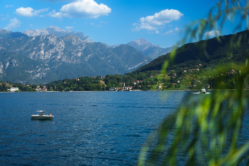 a boat floating on top of a lake surrounded by mountains