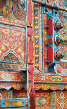 Traditional brass utensils and colorful truck art patterns decorating the restaurant walls.