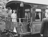 a black and white photo of a woman standing on a train