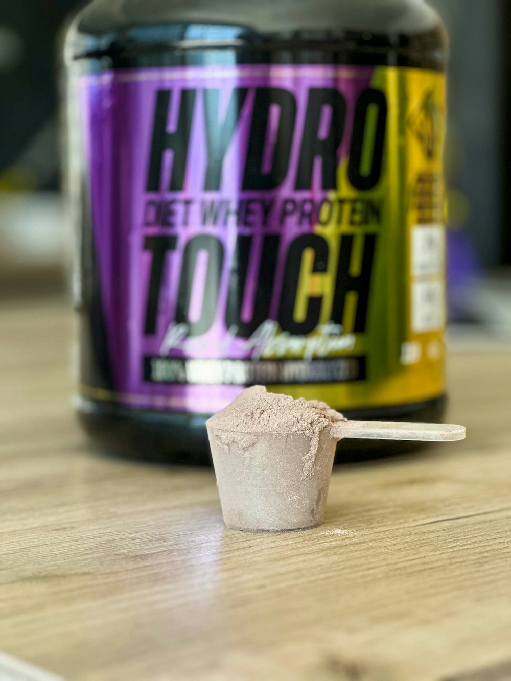 a jar of hydro protein and a spoon on a table