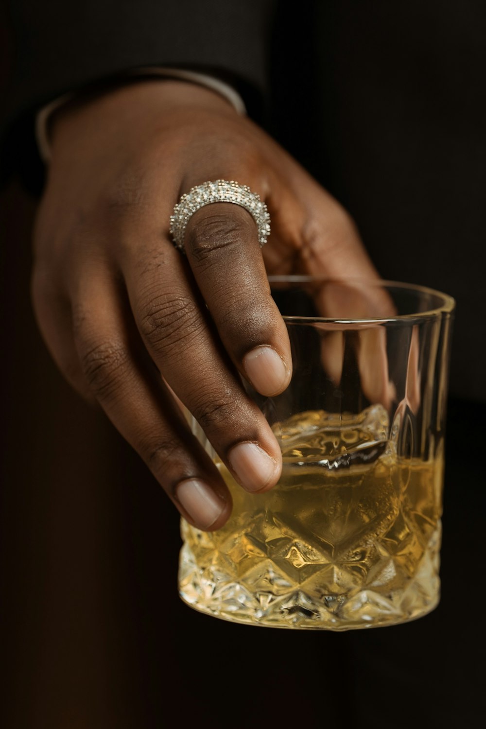 a person holding a glass with a ring on it