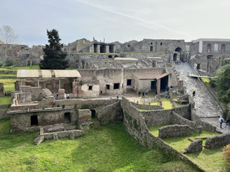 a group of people walking around a stone building