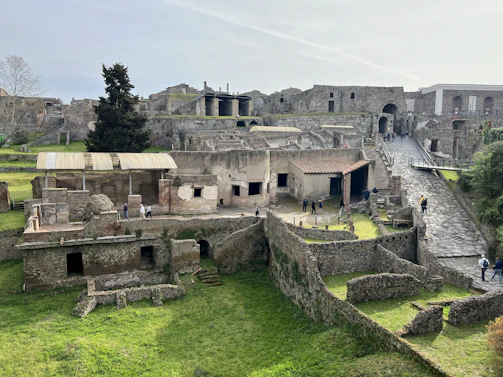 a group of people walking around a stone building