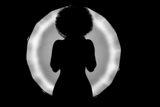 a silhouette of a woman standing in front of a circle