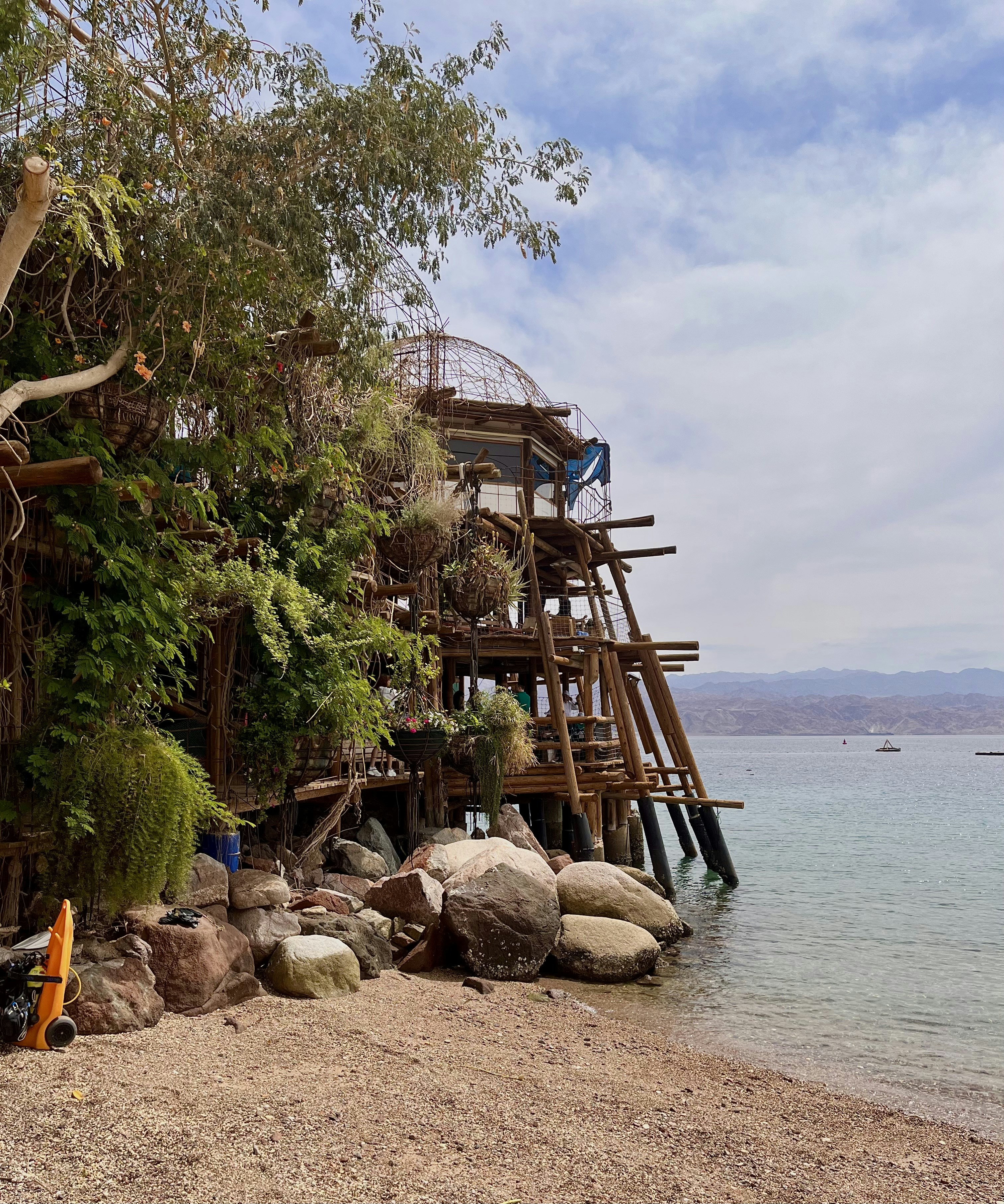 a wooden structure sitting on top of a beach next to a body of water