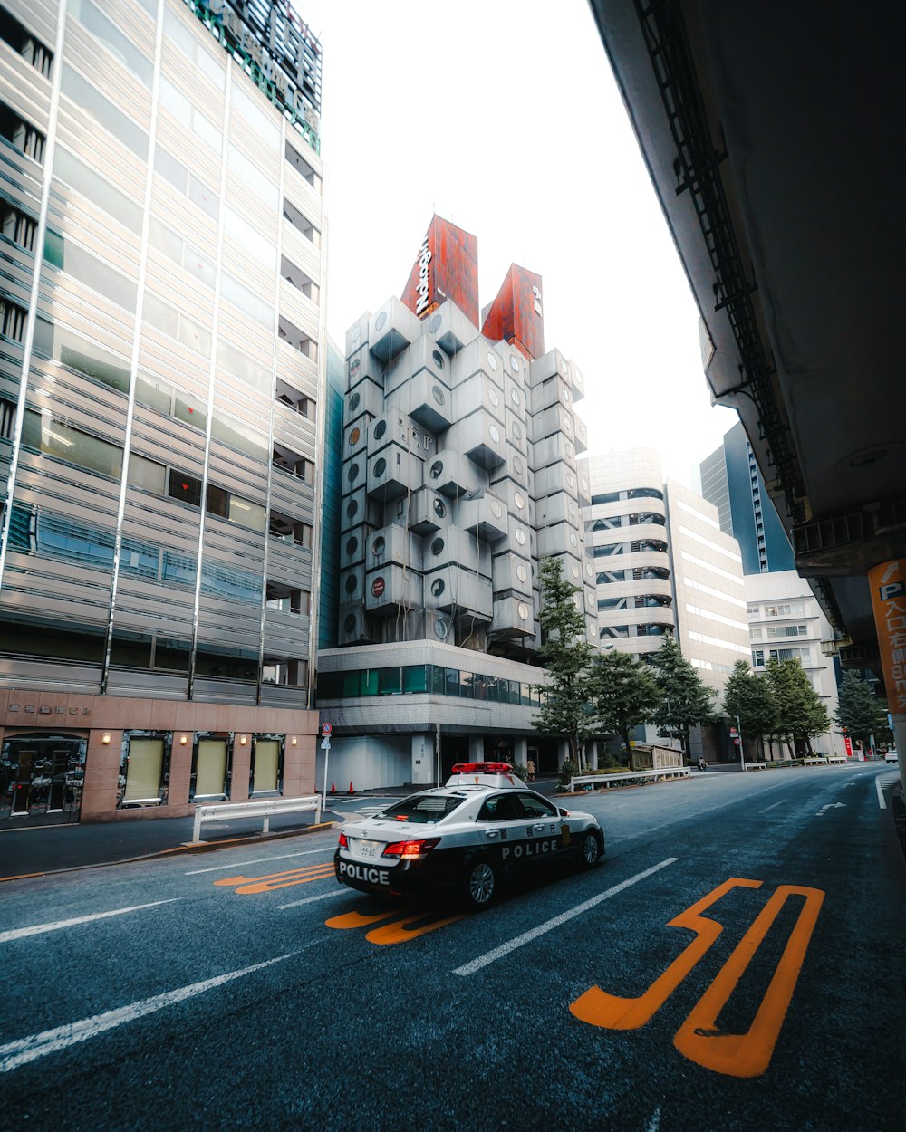 a police car driving down a street next to tall buildings