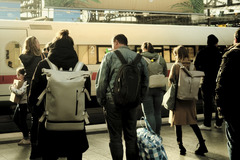 a group of people standing next to a train