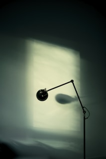 Minimalist floor lamp standing by a comfortable reading nook, creating a perfect serene corner