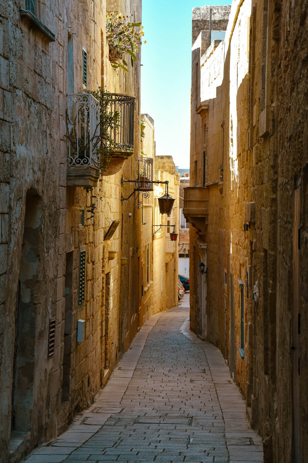 a narrow alleyway between two buildings with balconies