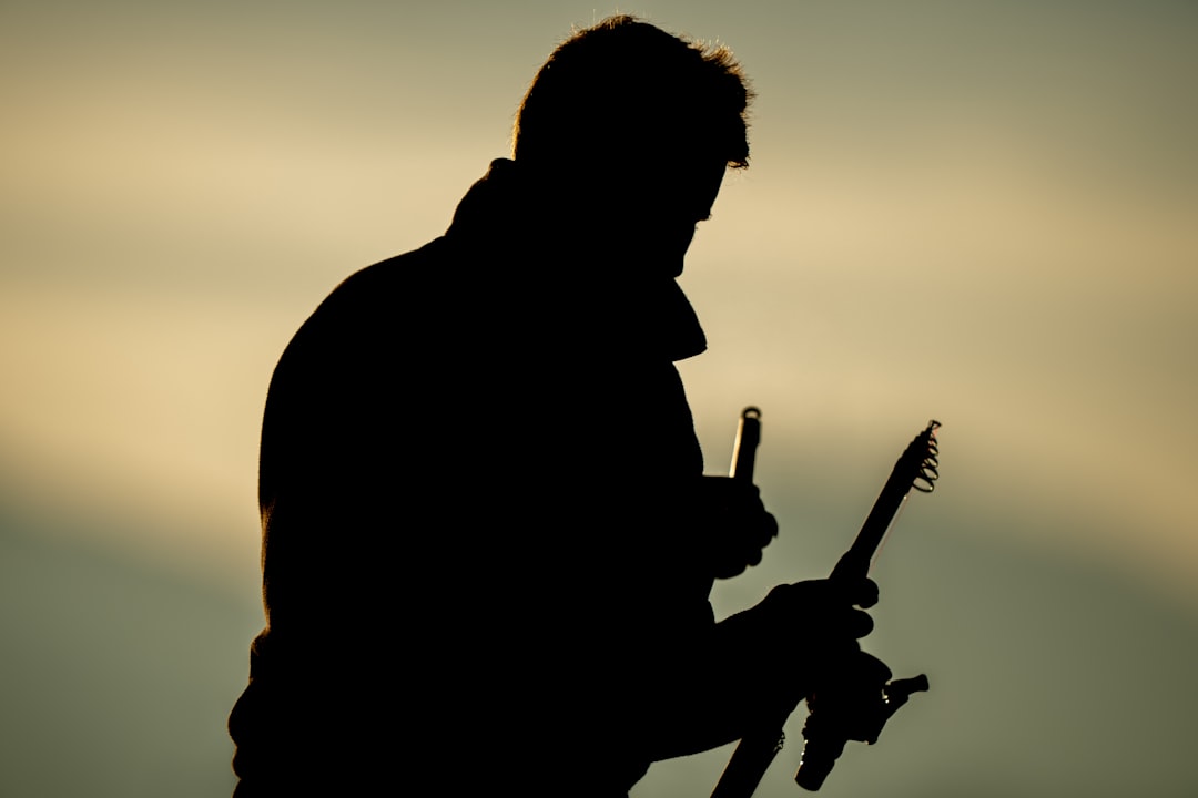 a silhouette of a man holding a guitar