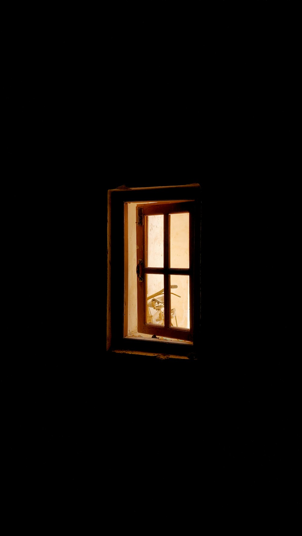 a window in a dark room with a light coming in
