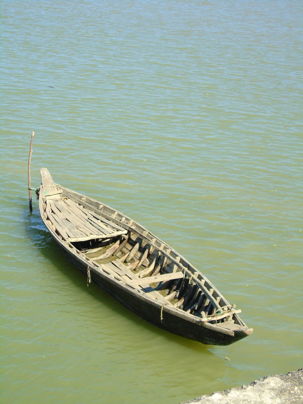 a small wooden boat floating on top of a lake