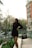 a woman standing on a ledge in a city