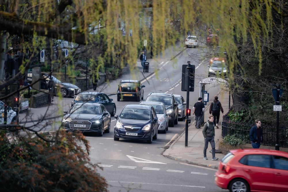 a group of cars driving down a street next to a traffic light