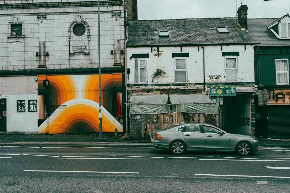 a car parked on the side of a road next to a building