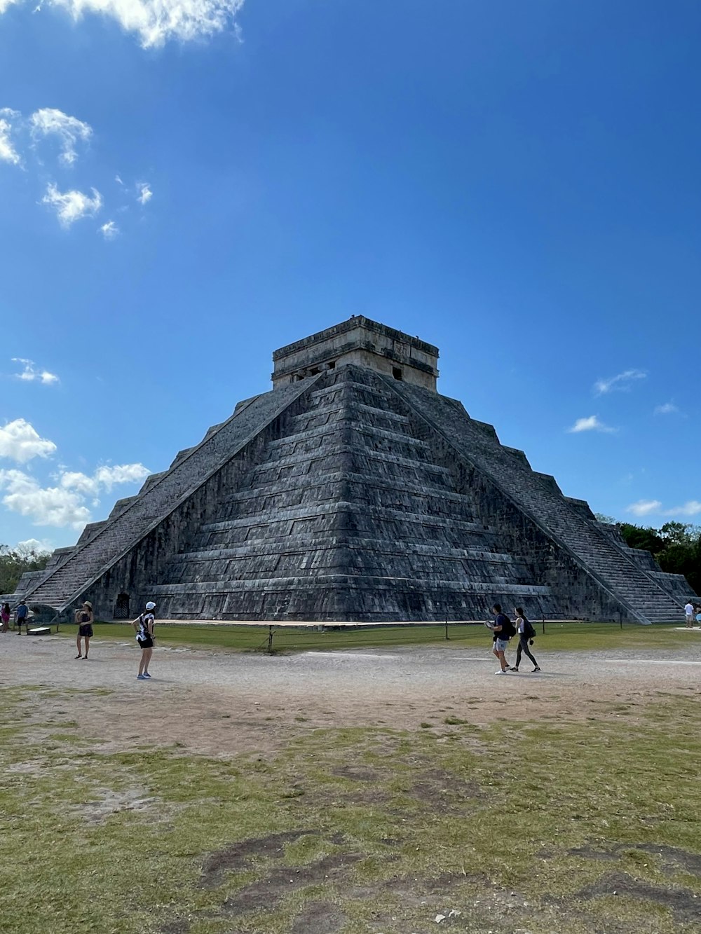 a group of people standing in front of a pyramid