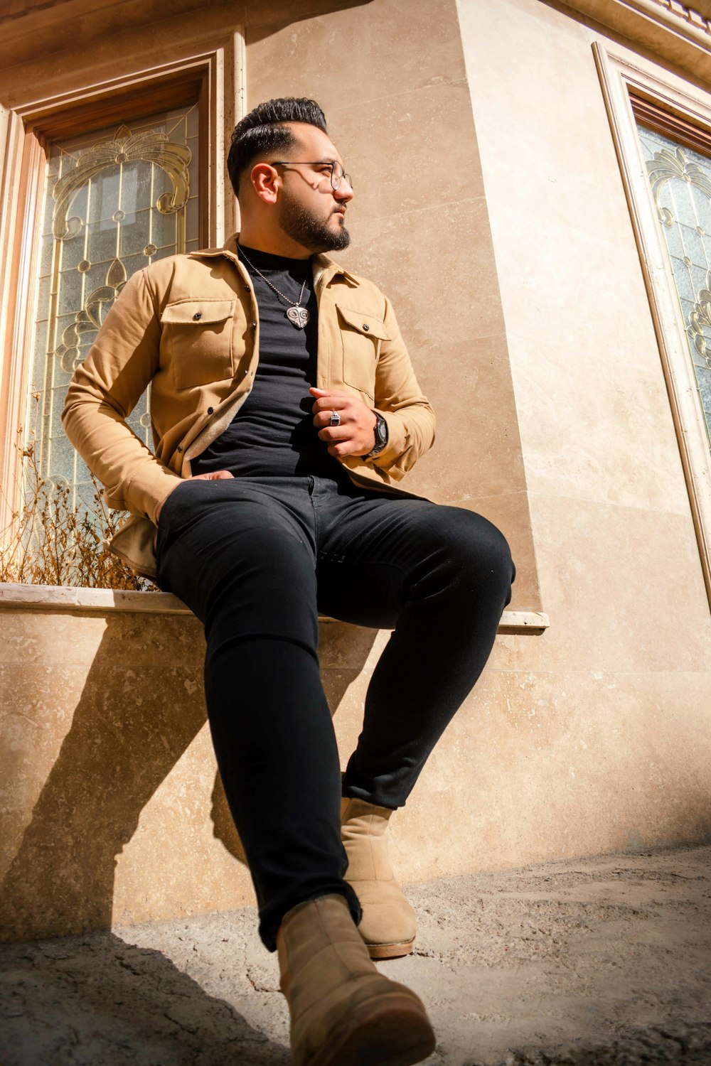 a man sitting on a ledge in front of a building