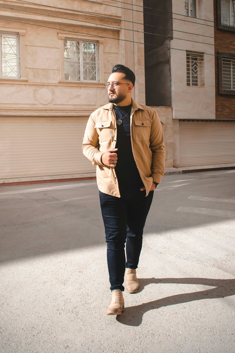 a man in a tan jacket is walking down the street