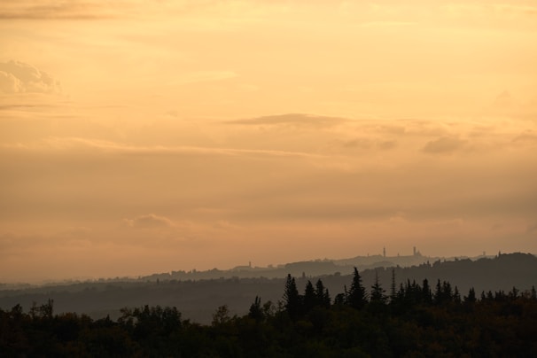 A serene landscape painting featuring rolling hills at sunset.