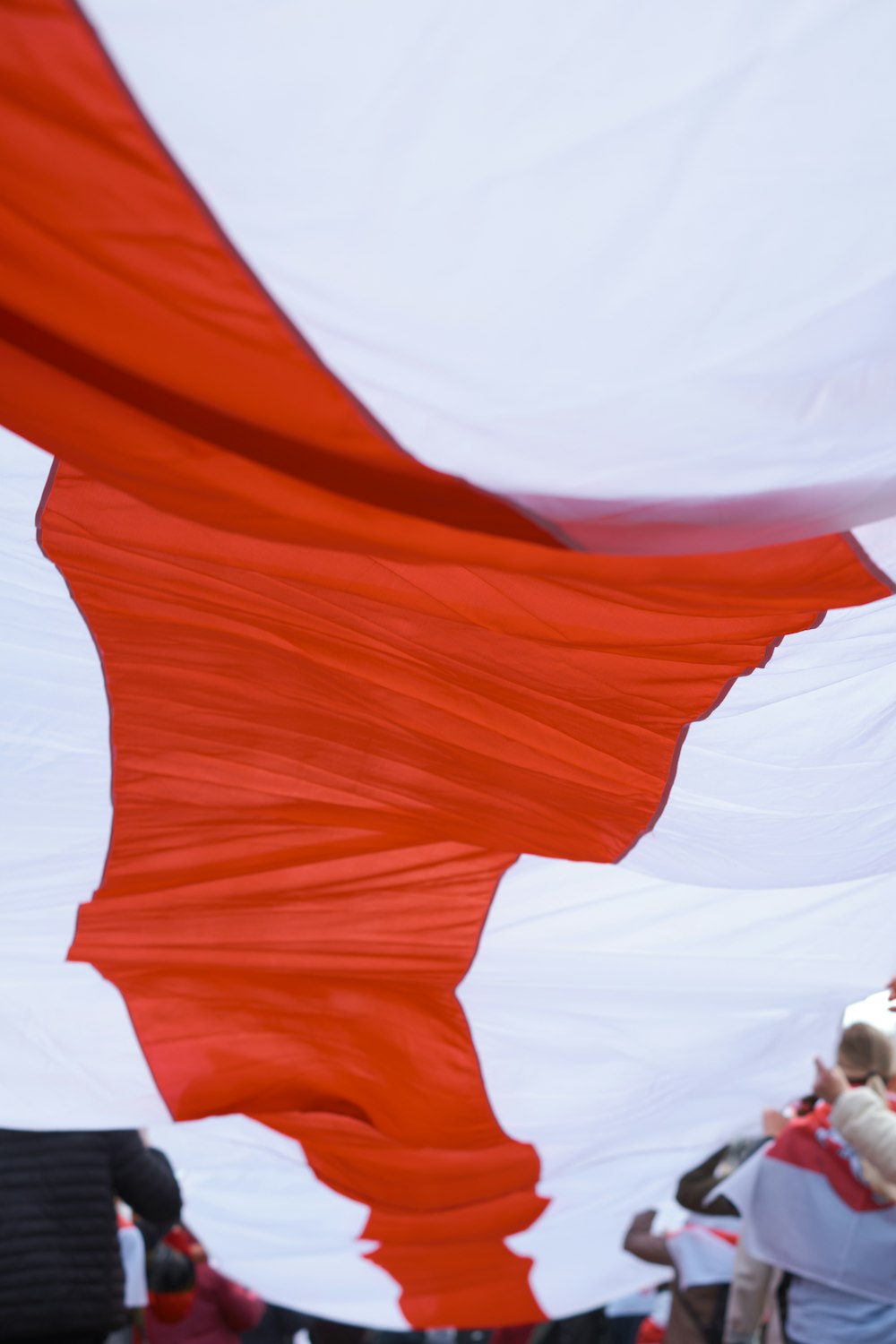 a large red and white flag flying in the air